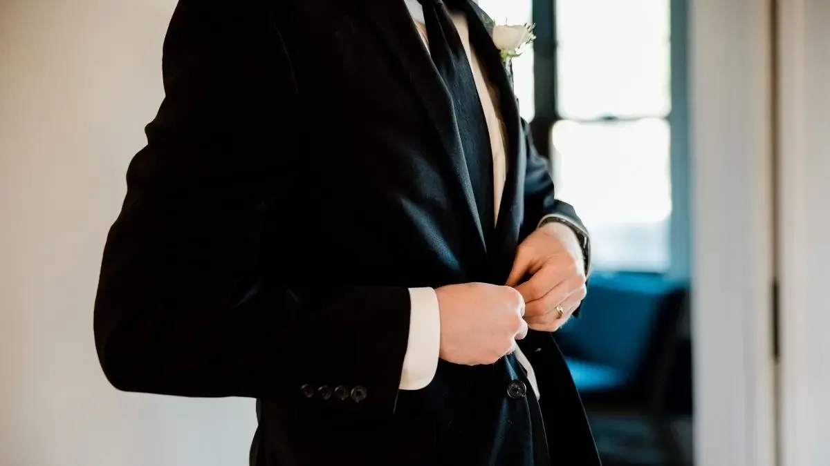 Novio vistiéndose con traje de bodas para el baile nupcial
